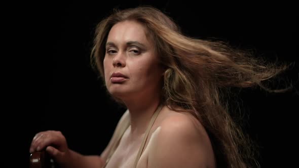 Closeup Side View Sensual Overweight Brunette Woman with Hair Blowing By Wind Posing at Black alt