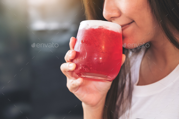 Closeup image of an asian woman enjoy drinking strawberry soda with feeling happy