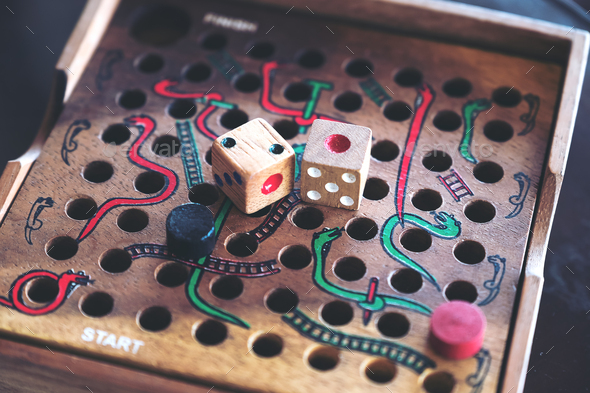 Closeup image of a wooden Snakes and Ladders game
