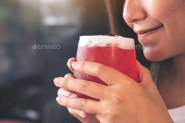 Closeup image of an asian woman enjoy drinking strawberry soda with feeling happy