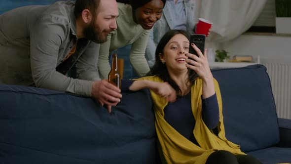 Group of Mixed Race People Spending Time Together While Looking at Comedy Video alt