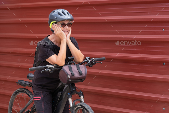 Happy senior woman cyclist in urban city excursion. Elderly people ejoying healthy lifestyle
