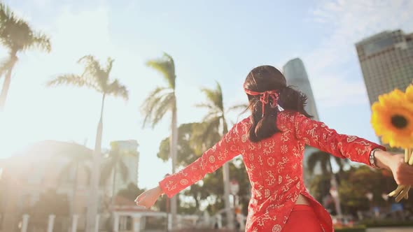 Girl in Traditional Vietnamese Dress Spinning Happy with Yellow Flowers alt