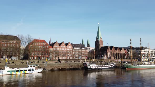 Pan along Bremen Weser promenade Schlachte with ships and view of St. Martini church and Teerhof bri alt
