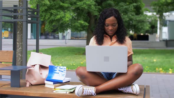 African Student Girl with Laptop and Books in City alt