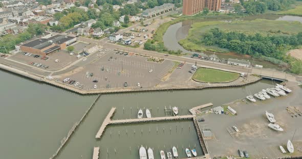 Aerial View of Motor Boats Lined Up Along the Dock on of a Near Little Seaside American Town alt