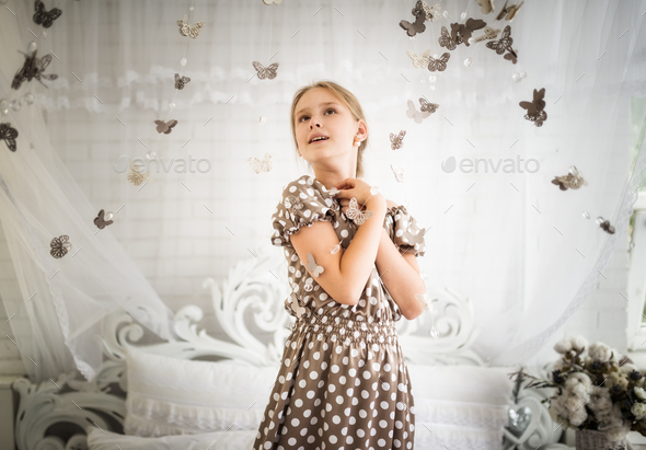 Bewitched little girl in a blue polka-dot dress