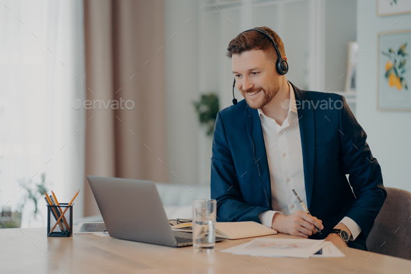 Smiling glad successful businessman practices online conference has distance meeting