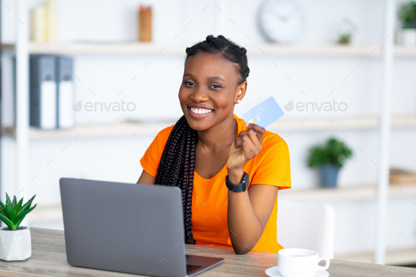 pot verdund fictie Cheery African American lady using laptop and credit card, buying things  online, shopping remotely Stock Photo by Prostock-studio