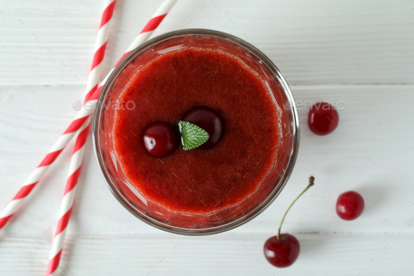 Glass of cherry smoothie, straws and ingredients on white wooden table  Stock Photo by AtlasComposer