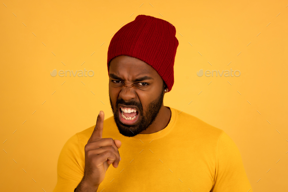 Angry man pointing to the camera while screaming to someone.