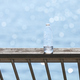 Plastic bottle left on a boardwalk railing against the sun. - PhotoDune Item for Sale