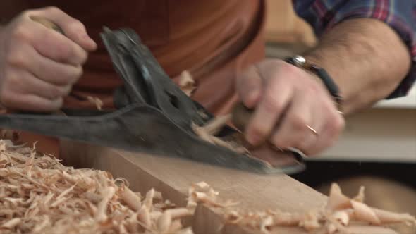 Cabinet-Maker Planes Solid Wood in his Workshop