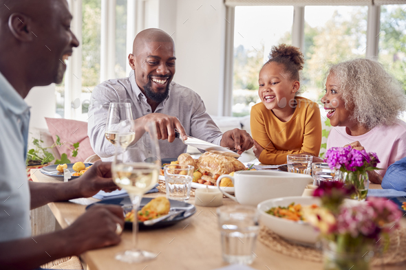 Father Carving As Multi Generation Family Sit Around Table At Home And ...