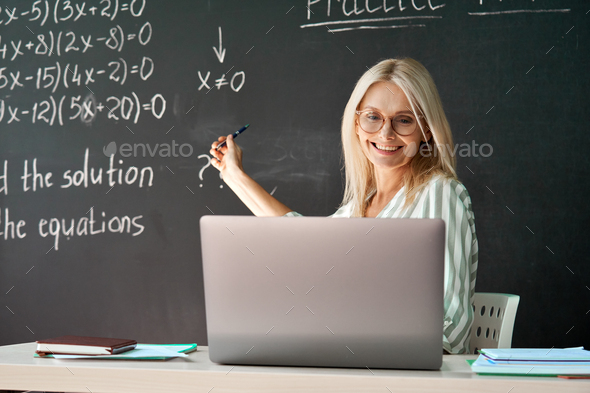Female school college teacher having online distance virtual class in classroom.