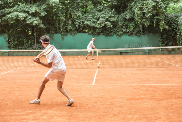 sportsmen playing tennis with wooden rackets on court together