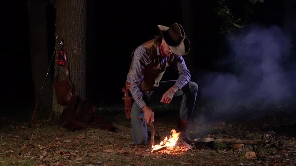 Cowboy Near the Fire in the Forest at Night alt