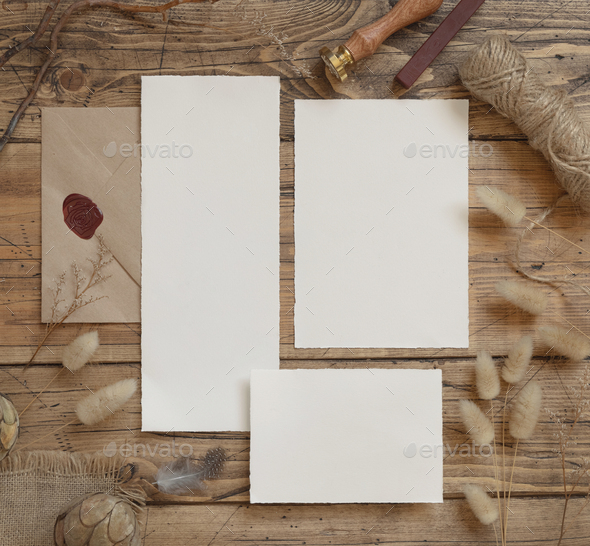 Wedding blank cards laying on a wooden table with bohemian decoration