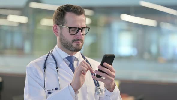 Portrait of Young Male Doctor Using Smartphone alt
