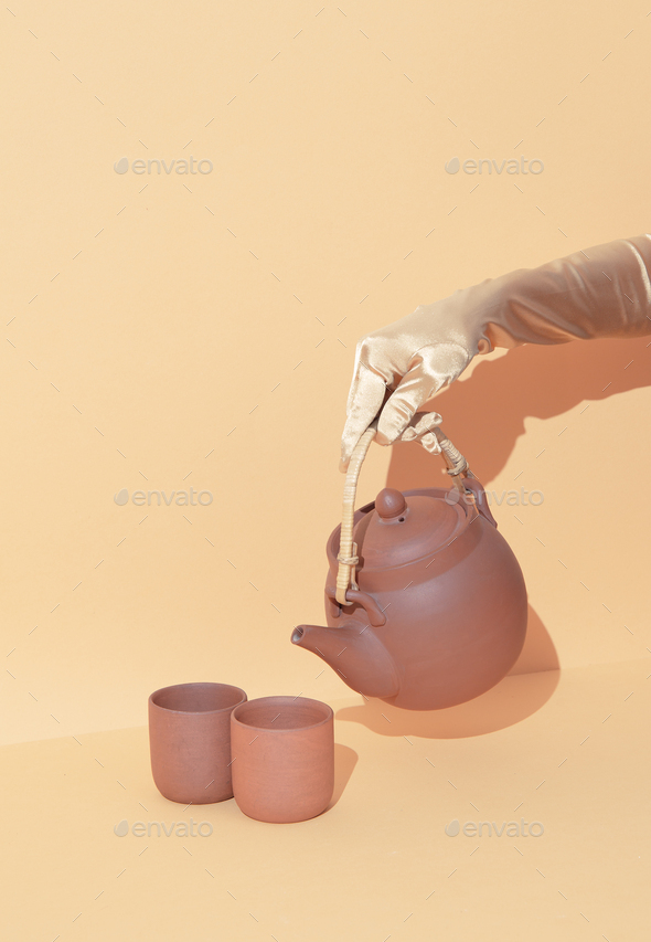 Hand holding Clay teapot minimal still life concept. Winter warm holiday  time wallpaper Stock Photo by EvgeniyaPorechenskaya