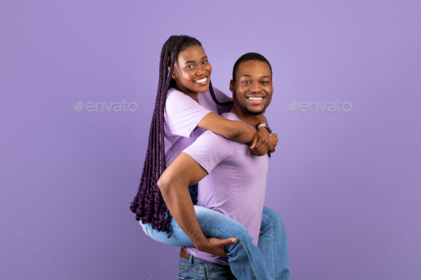 Girl giving her friend a piggyback ride stock photo