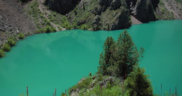 Mountain Lake of green and blue color Urungach and pine trees. Located in Uzbekistan, Central Asia. alt