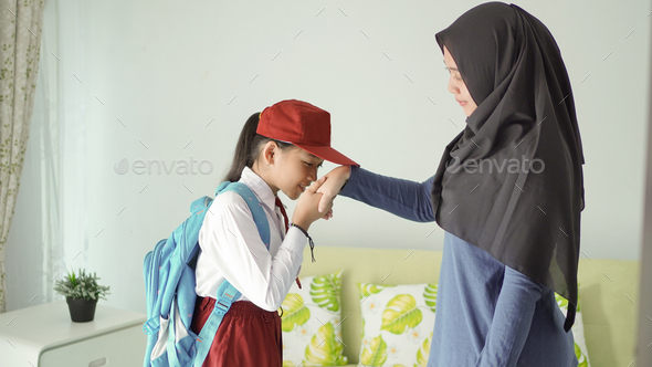 elementary school kid who kisses his mother\'s hand before going to school to say goodbye