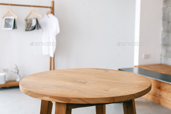 Closeup image of a wooden table and clothes rank in minimalist house