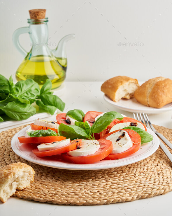Italian caprese salad with sliced tomatoes and mozzarella. Mediterranean cuisine. Delicious meal - Stock Photo - Images
