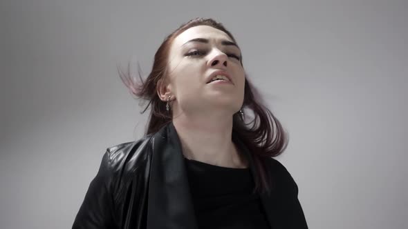 Portrait of Young Girl with Brown Eyes Whipping Hair and Moving Fists in Anger alt