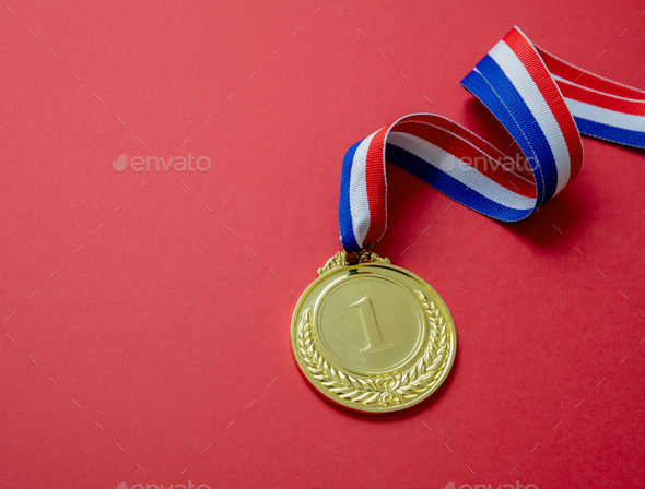 Gold medal. Champion trophy award and ribbon. Prize in sport for winner isolated on red background
