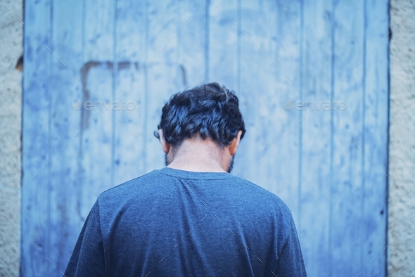 Man turning back to camera feeling alone. Rear view of thoughtful man feeling lonely or sad