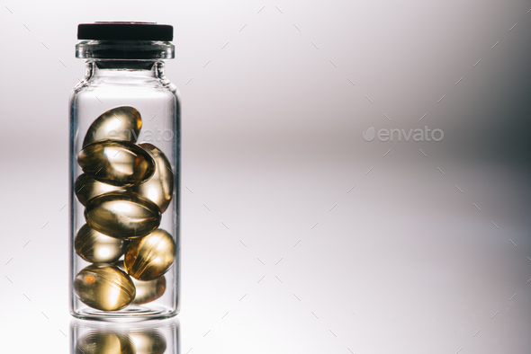 medical pills with transparent shell in bottle on grey background