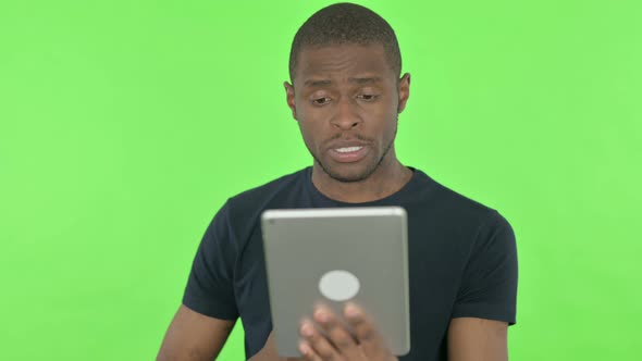 Video Call on Tablet By Young African Man on Green Background alt