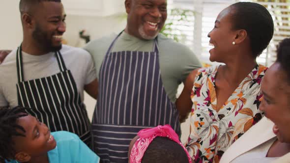 Three generation african american family smiling together in the kitchen at home alt