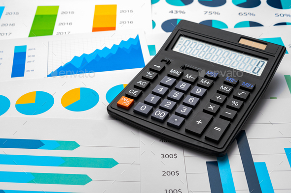 Business graphs paper and calculator on table - Stock Photo - Images
