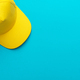 Top View Of Yellow Baseball Cap Over Turquoise Blue Background With Copy Space - PhotoDune Item for Sale