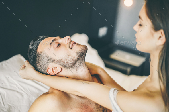 Young passionate couple having sex on the bed at home Stock Photo by biasciolialessandro image