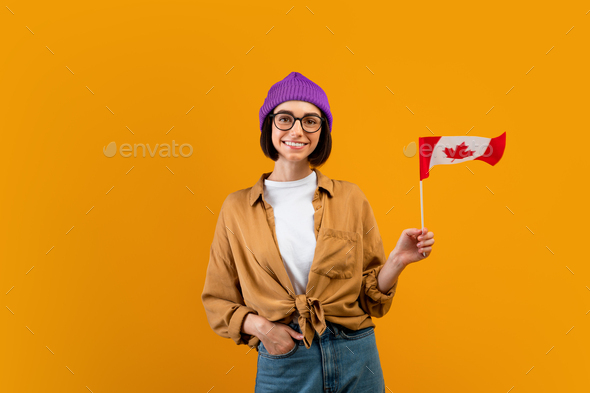 Education abroad, studying in Canada, emigration concept. Positive woman student holding flag over