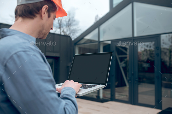 Man with laptop in front of smart home