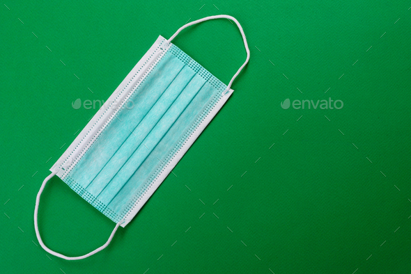 Medical mask on a colored background, a means of protection against coronovirus and epidemic