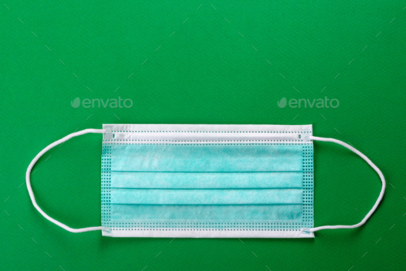 Medical mask on a colored background, a means of protection against coronovirus and epidemic