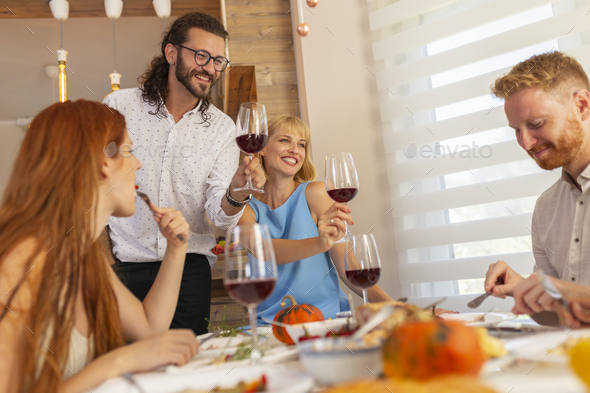 Hosts entertaining guests over Thanksgiving dinner