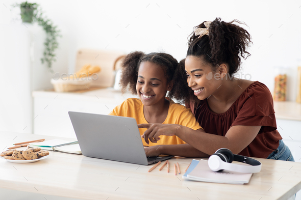 Creative black mother and daughter working on school project - Stock Photo - Images