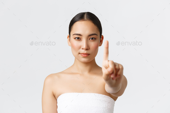 Beauty, cosmetology and spa salon concept. Confident beautiful asian woman showing finger in stop
