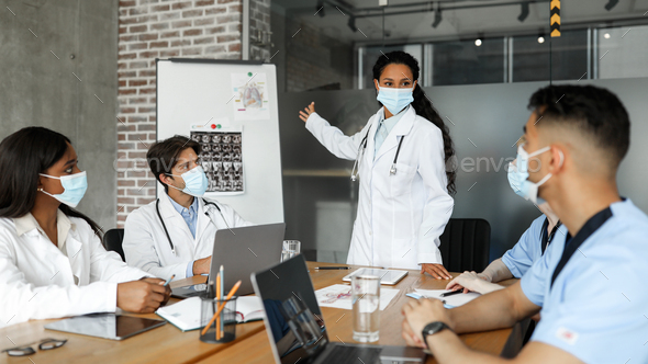 Multiracial group of doctors in face masks having medical conference