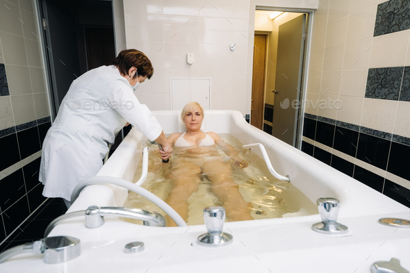 the procedure of underwater shower massage in the bathroom.Girl on the procedure of underwater
