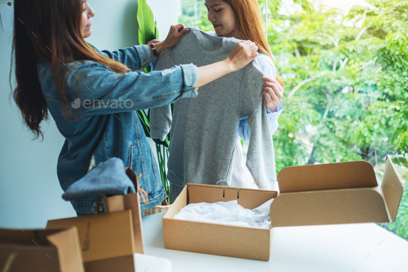 Women receiving a postal parcel box and try on clothes at home for delivery and online shopping