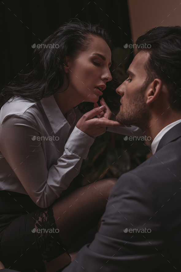 Attractive Sexy Secretary Touching Chin Of Handsome Businessman Stock