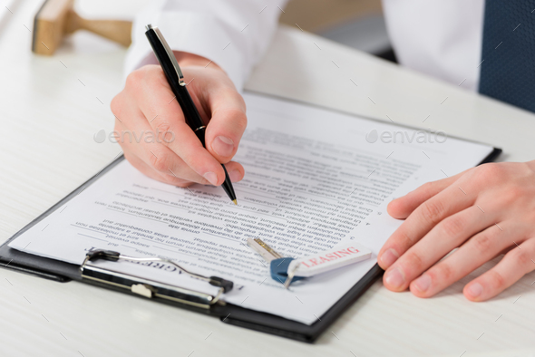 cropped view of businessman holding pen near clipboard with document and key with leasing lettering - Stock Photo - Images